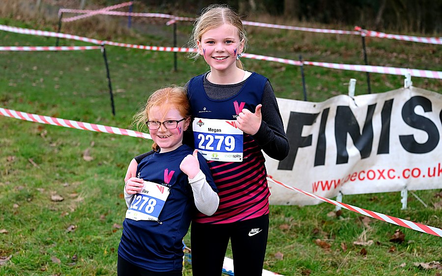 Two young Vale of York runners in club vests at the finish of a PECO cross country race