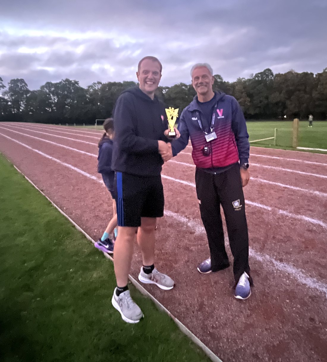 James Leadbeater receiving the club volunteer trophy from Ian Martin on the track at Tadcaster